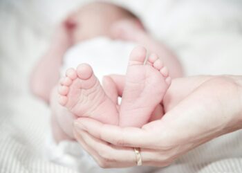 close up of hands holding baby feet