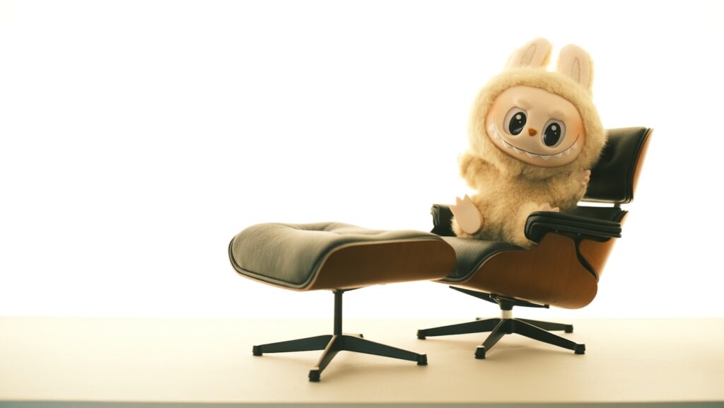 A cute stuffed animal sits on a comfortable chair.