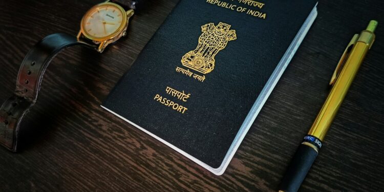 a passport, watch and pen on a table